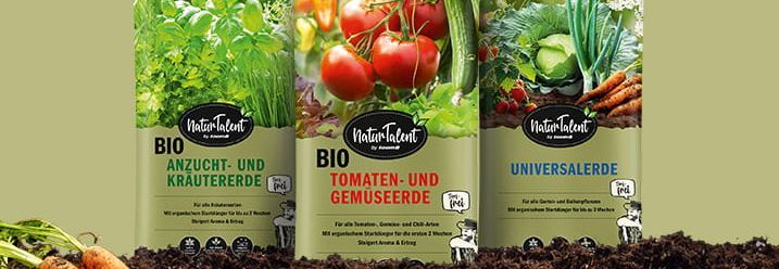 Drei Säcke Blumenerde auf einem Erdhaufen